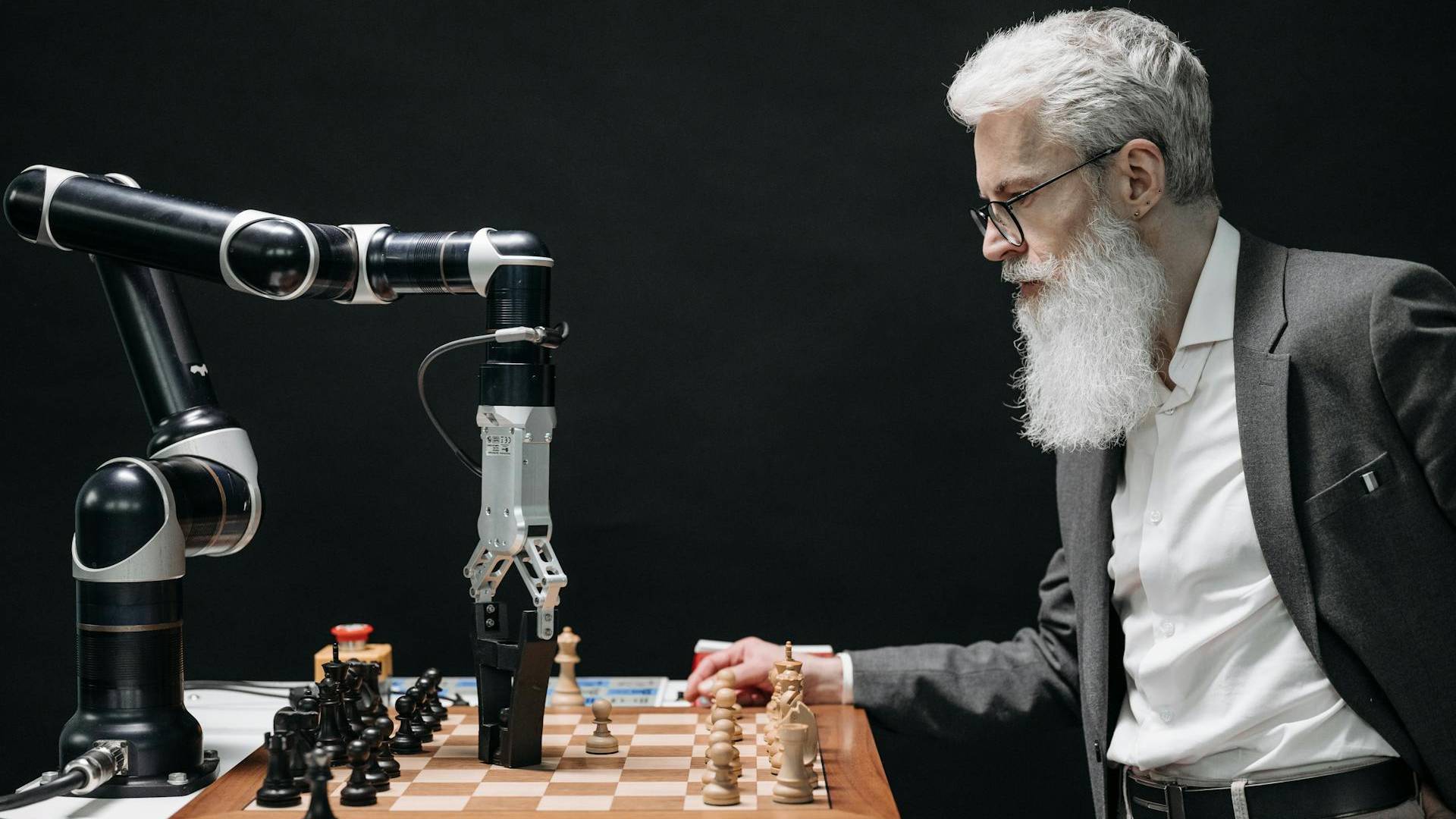 Ein Mann im Anzug spielt Schach gegen einen Roboter