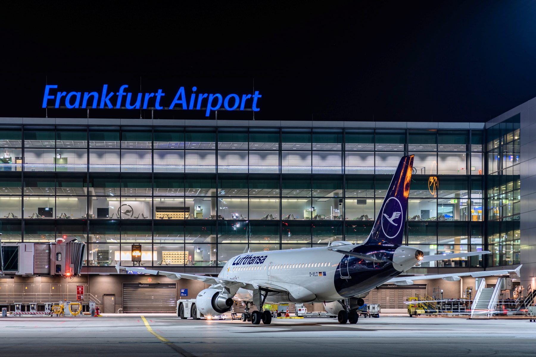 Frankfurt Airport (Fraport), davor steht ein Lufthansa Airbus LH A319-100 beim Pushback bei Nacht